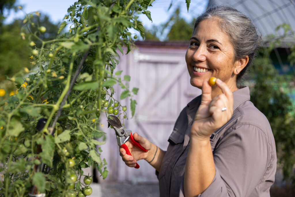 Holly Jones holding up a small tomato