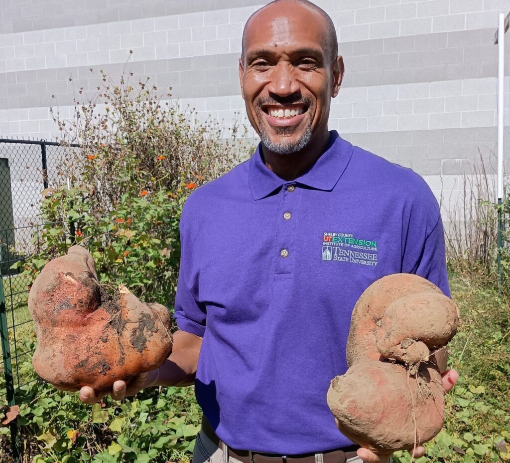 Chris Cooper holding two large root vegetables