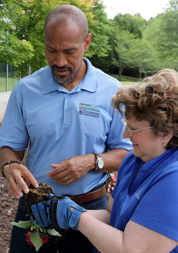 Chris Cooper examining roots of a plant