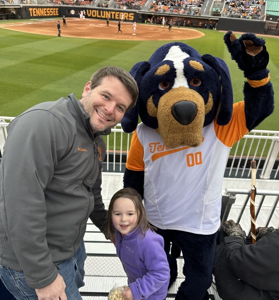 Karen’s husband, Trey, and their daughter, Kaylee, with Smoky at a Tennessee Lady Vols softball game.