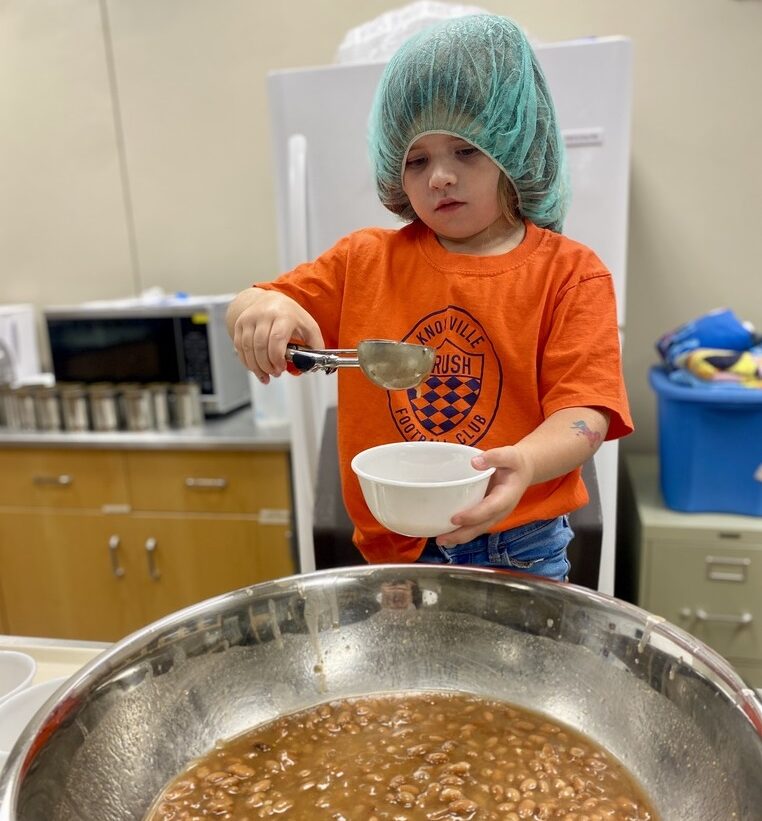 a child scooping beans into a bowl