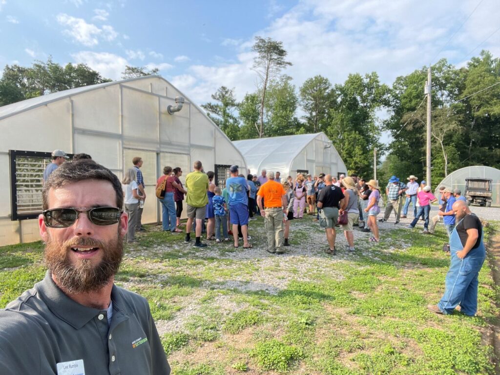 Lee Rumble behind a group at a green house presentation