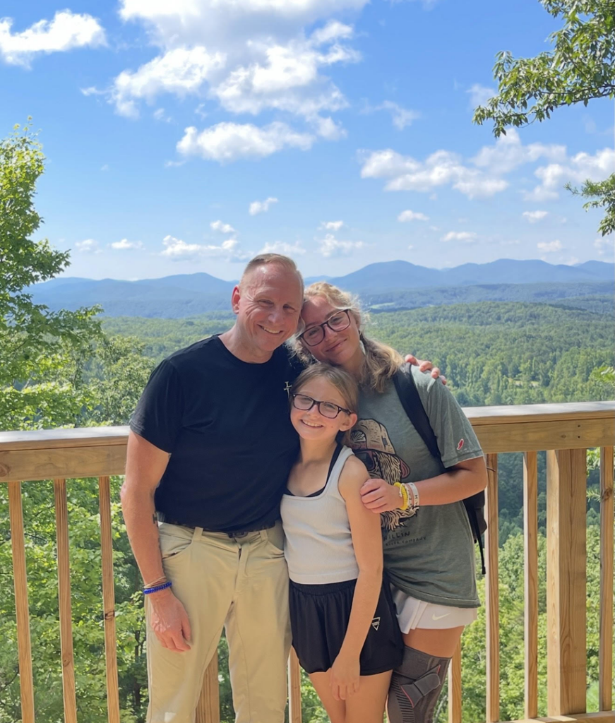 Anna and family in the outdoors with mountains in the background
