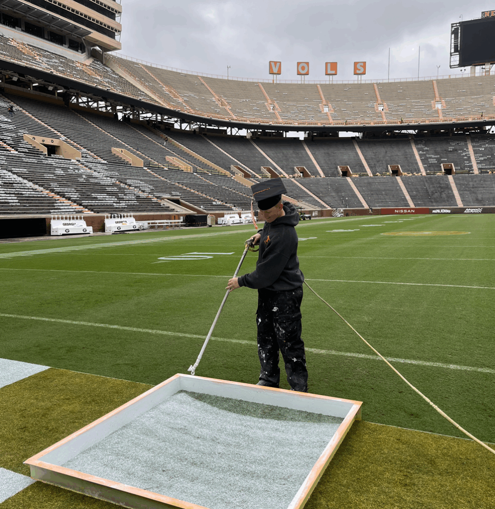 Luke Bennett spraying paint for the checkerboard endzone in Neyland Stadium