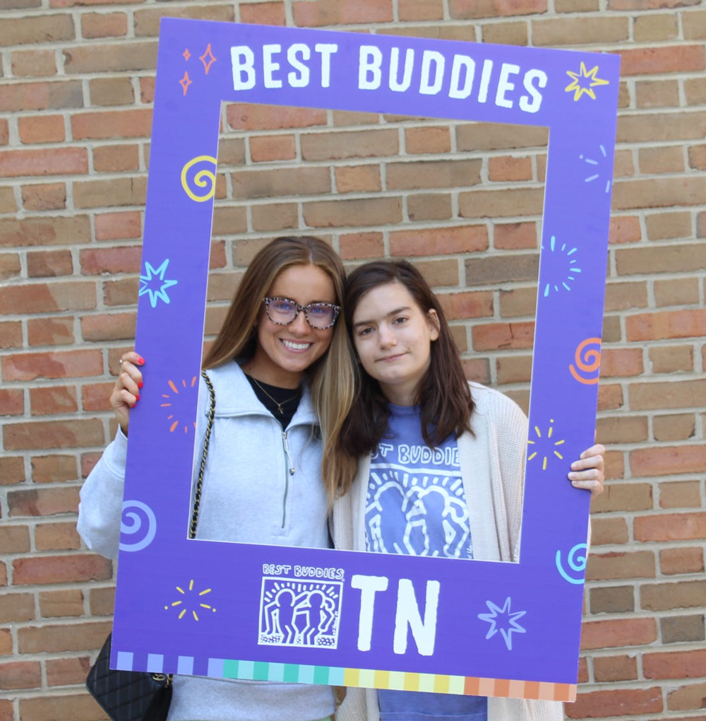 Haylee Ferguson and another girl holding a purple sign that reads: Best Buddies TN