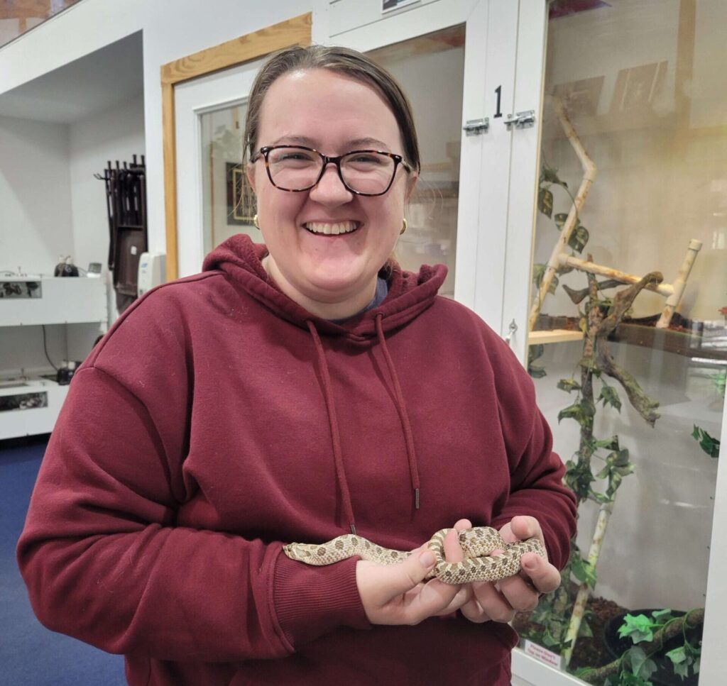 Haley Williamson smiling while holding a snake.