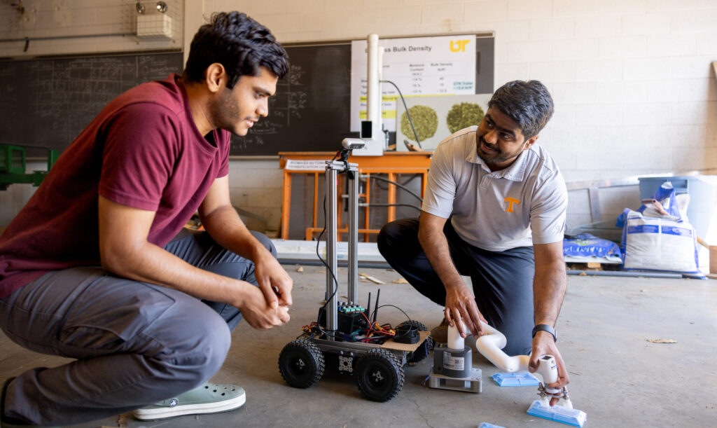 Chetan Badgujar and a student work together on a robotic device in a workshop.