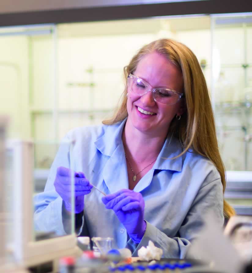 Woman smiling as she works in lab