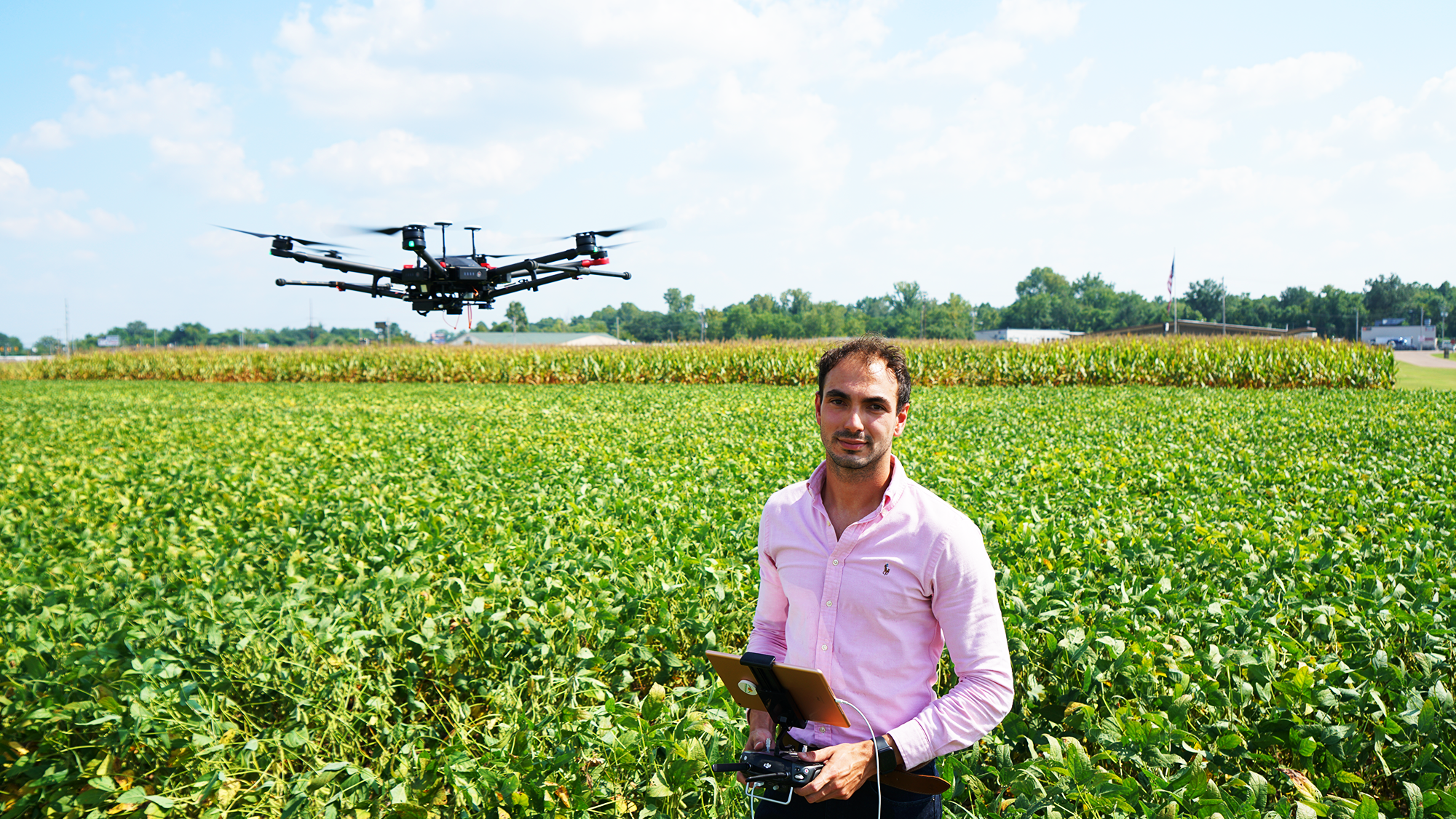 Elias in a field controlling a drone flying above