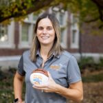 Karen DeLong holding a "Lady Vols" basketball