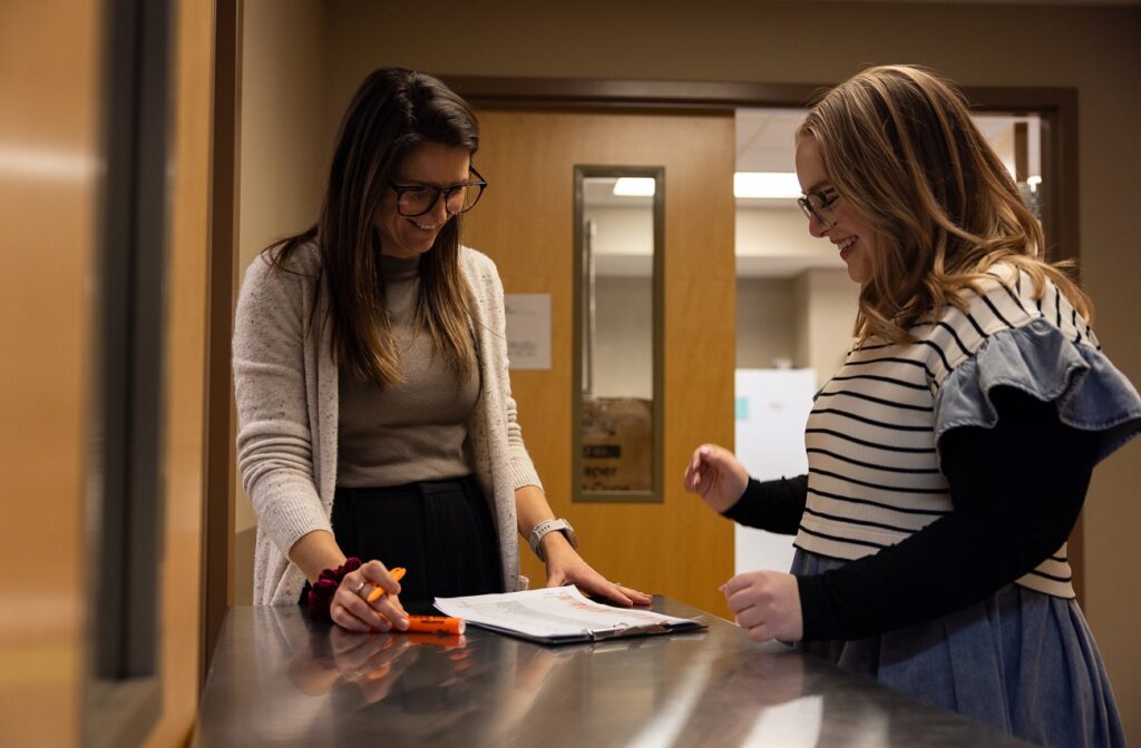 Sara Burns at the UT Food Sensory Lab with a checklist of people participating in a test