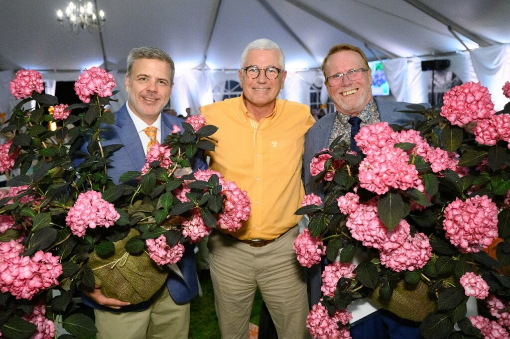 James Newburn holding a plant with pink hydrangeas at the annual Gardens Gala