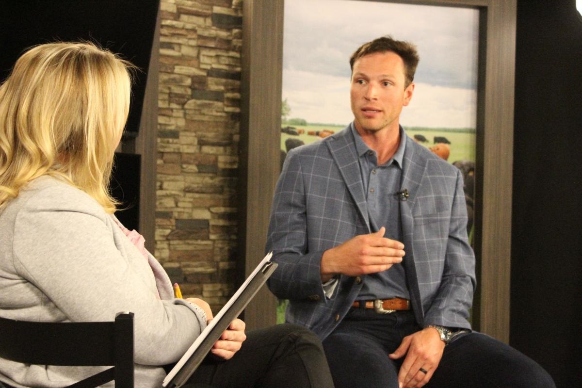 Joe Lowe speaking with a woman in an interview