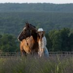 Marisa Shulman in a field with a brown horse
