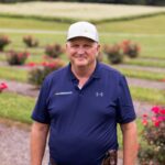Walt Hitch in front of rose bushes
