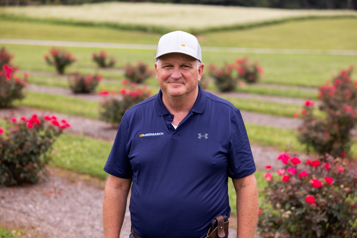 Walt Hitch in front of rose bushes