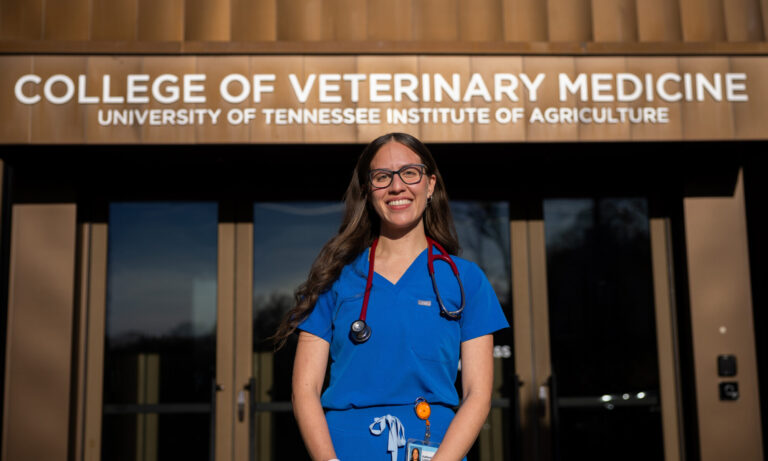Katherine Lopez stands outside of a building labeled "College of Veterinary Medicine, University of Tennessee Institute of Agriculture."