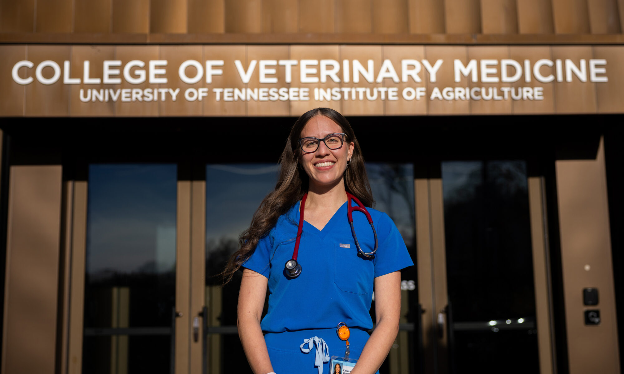 Katherine Lopez stands outside of a building labeled "College of Veterinary Medicine, University of Tennessee Institute of Agriculture."
