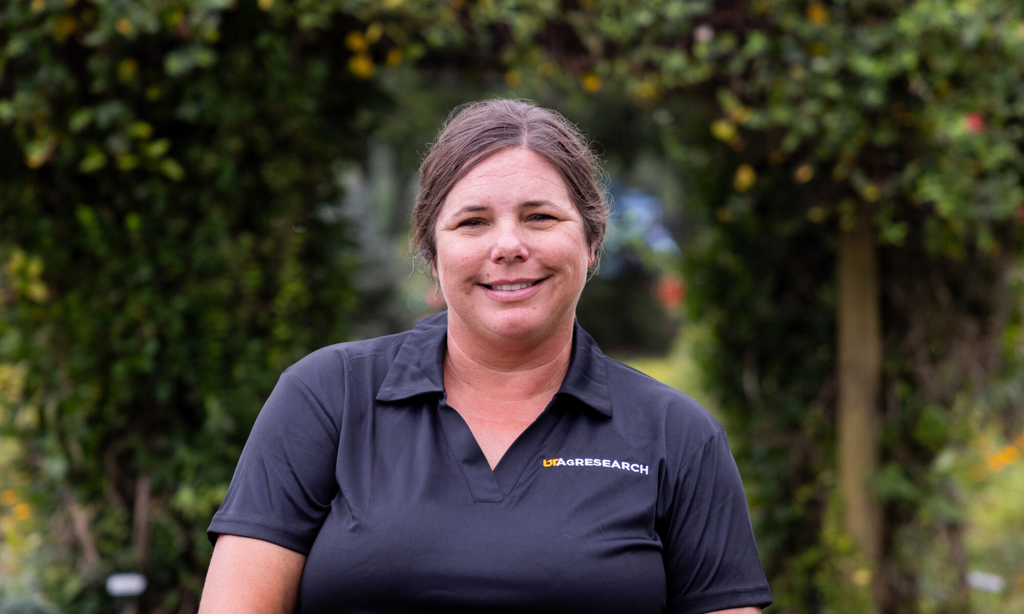 Portrait of Shalena Durkot smiling with greenery in the background.