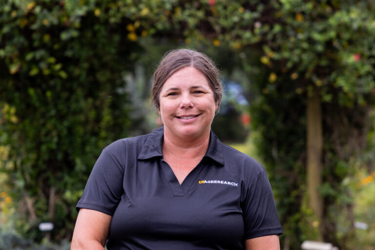 Portrait of Shalena Durkot smiling with greenery in the background.