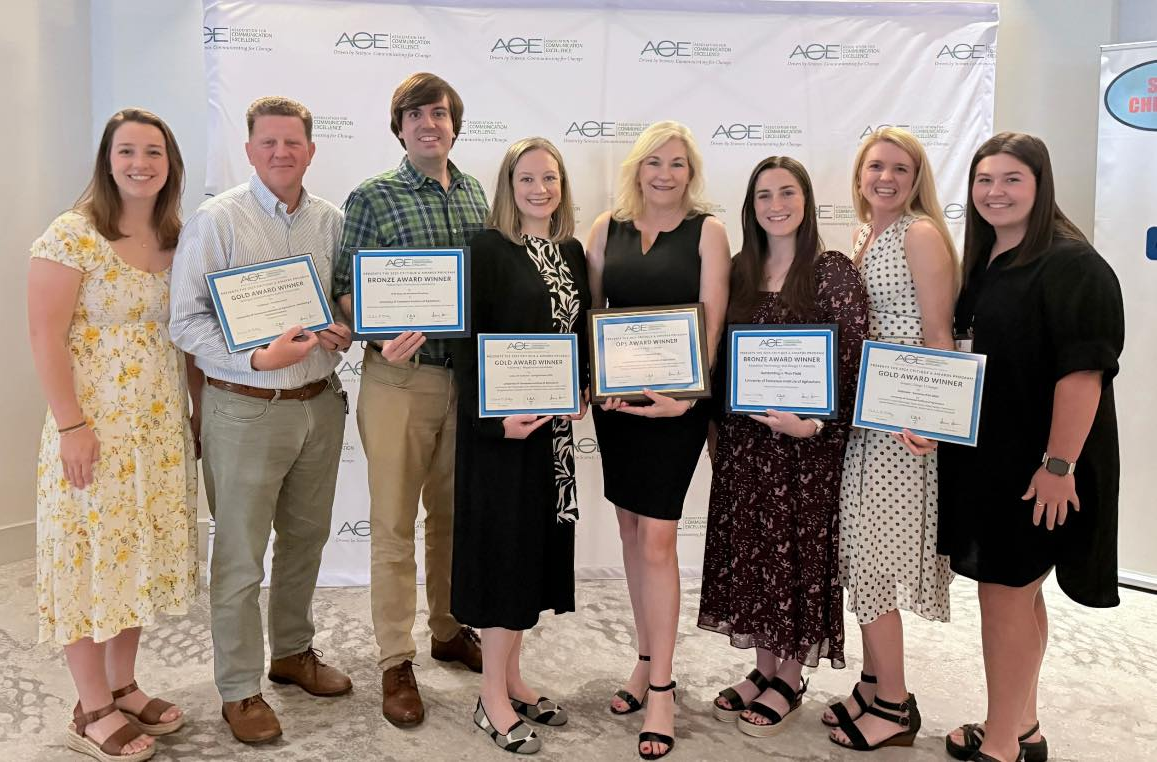 Marketing and communications professionals holding their award certificates