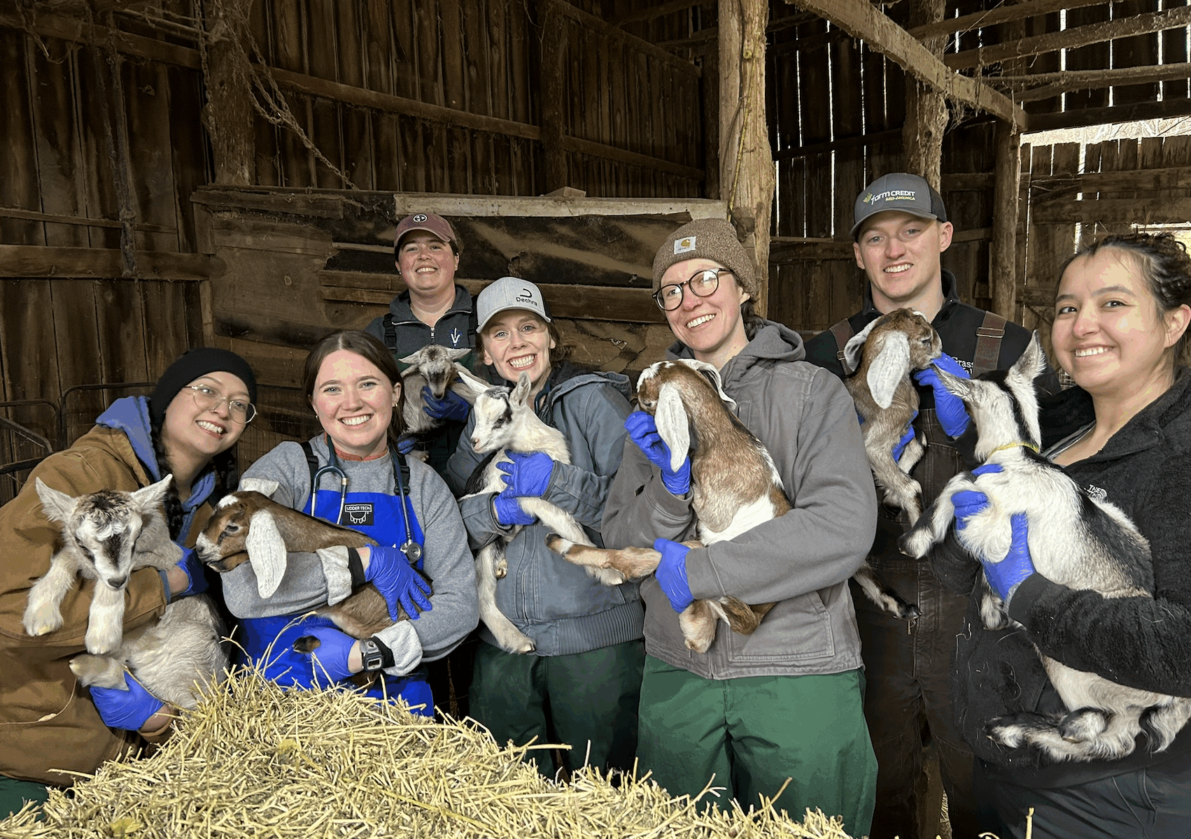 Members of the Class of 2025 and farm animal medical resident Lyndsee Miniard, third from left, hold dairy goat kids during a farm animal call. Photo by Andi Lear