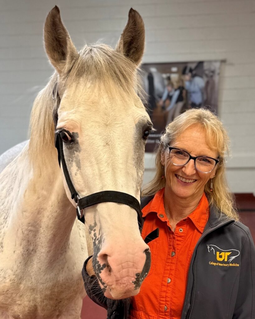 Dr. Carla Sommardahl stands with a white horse.